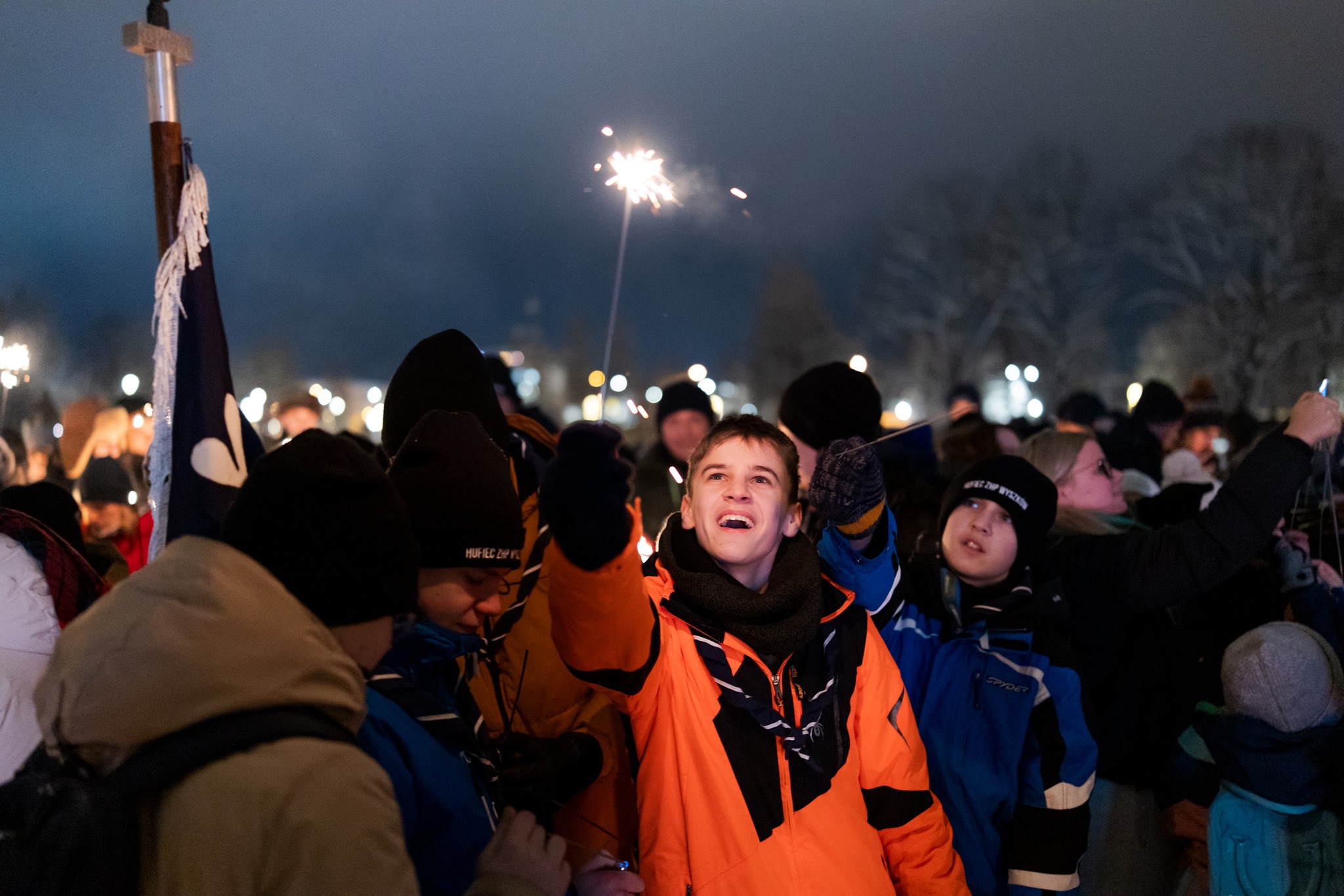 Betlejemskie Światło Pokoju 2024 - harcerz w chuście trzyma zimne ognie.