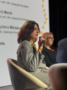 Tradycja, służba i kompetencje na całe życie. Kongres 80-lecia ZHP na Dolnym Śląsku 4 Instruktorka ZHP w mundurze, trzyma w ręce mikrofon i wypowiada się w trakcie kongresu.