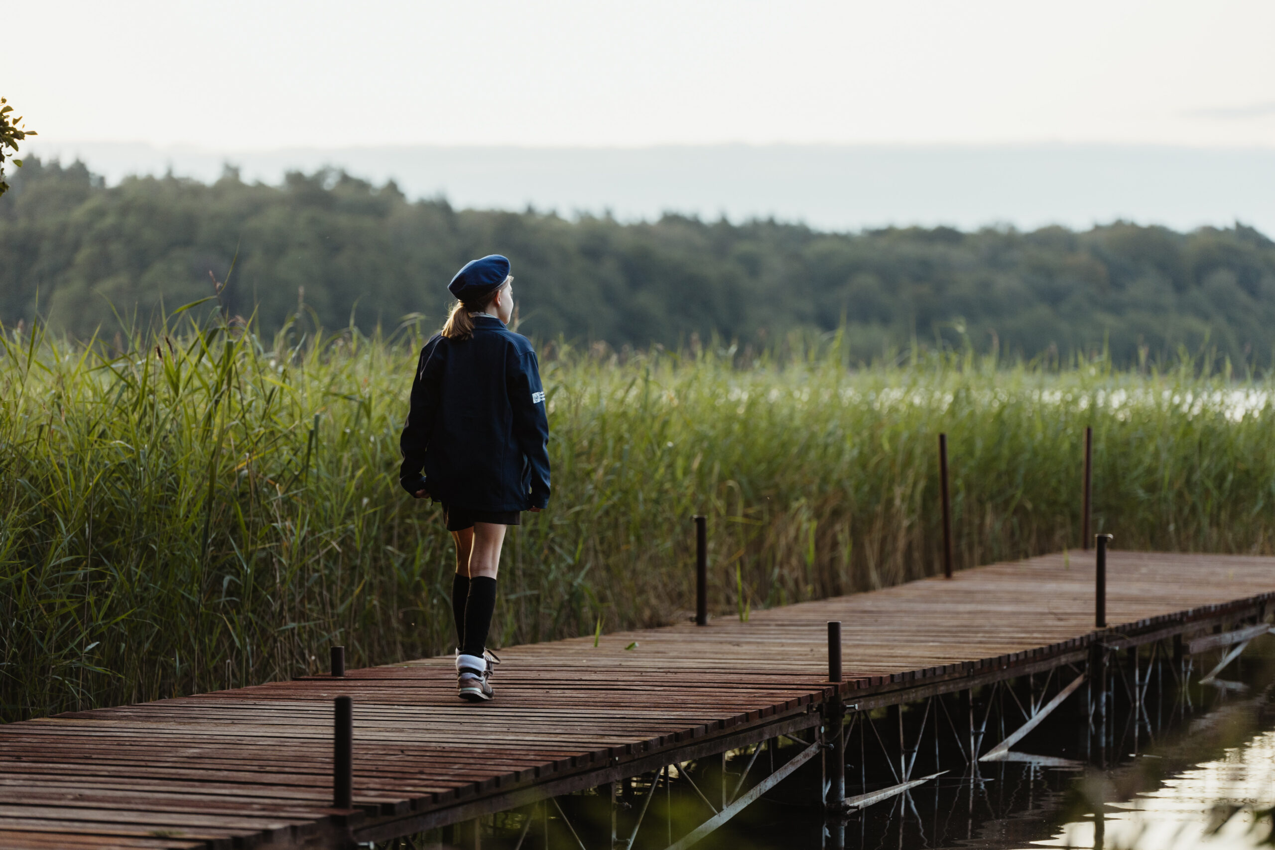 Harcerstwo i siła bycia sobą – jak harcerstwo pomaga zaakceptować siebie - harcerka na pomoście idąca w stronę wody