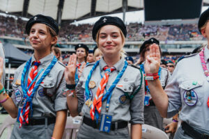 Ludzie, którzy sprawiają, że Światowe Jamboree Skautowe Polska 2027 będzie wyjątkowe - International Service Team ZHP! 2 International Service Team - harcerka ZHP w pełnym umundurowaniu, z czerwoną chustą, na stadionie podczas ceremonii zakończenia zlotu w 2023 roku.