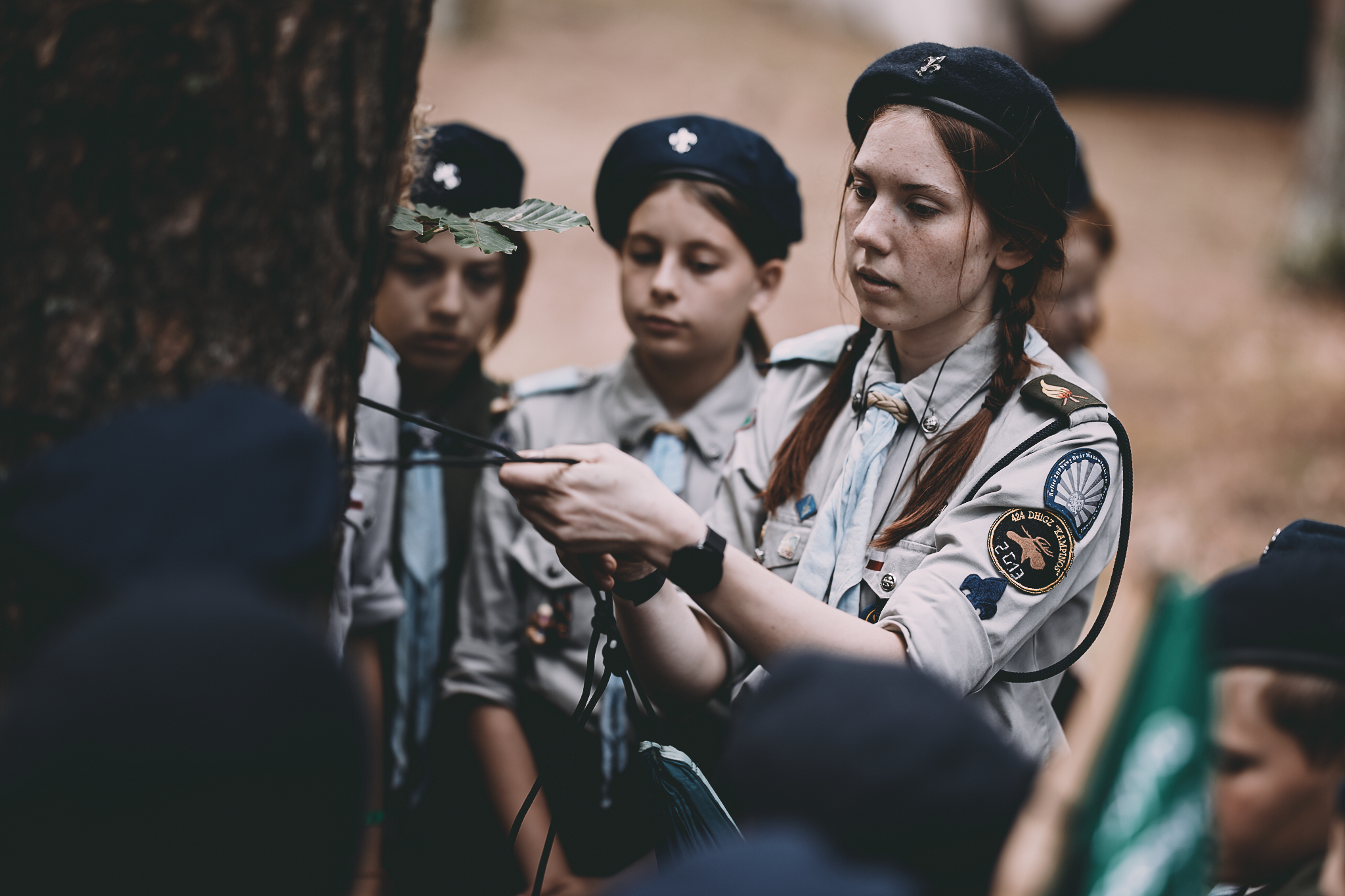 Drużynowy w ZHP – kim jest i dlaczego jego rola jest tak ważna? - Drużynowa w mundurze uczy harcerzy wiązać węzły na drzewie